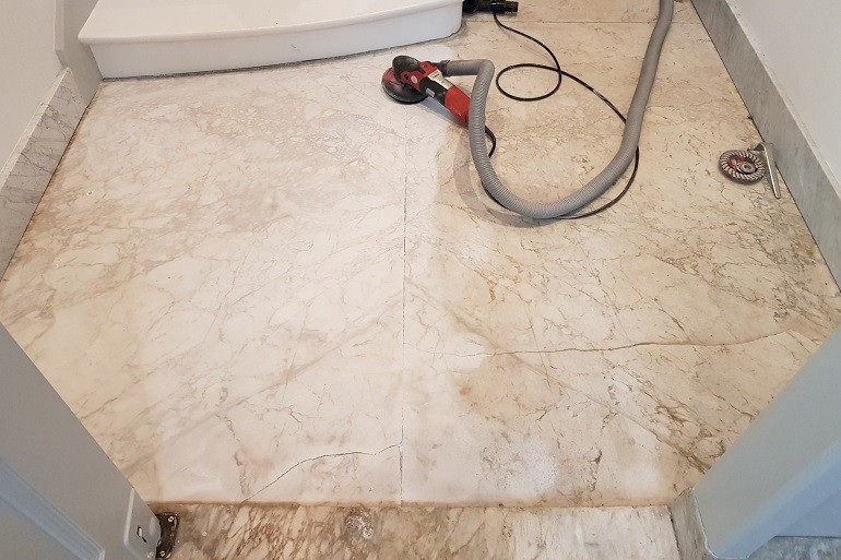 Carrara marmer vloer in de hal schoonschuren van oude vervuiling en bruine laag.