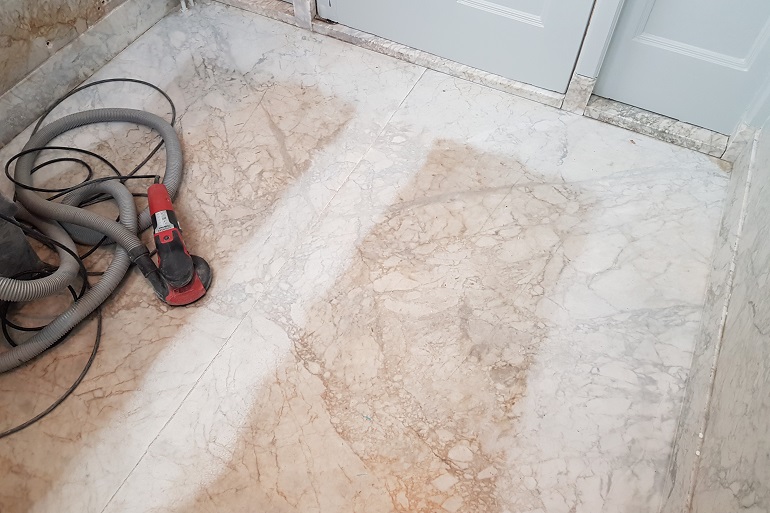 Beschadiging in Carrara marmeren vloer schuren Beschadiging in Carrara marmeren vloer schuren