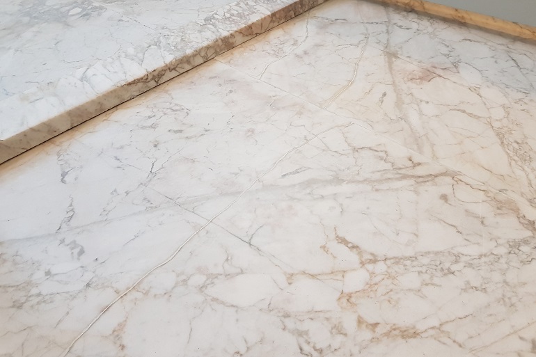 Herstelde scheur in Carrara marmeren vloer Herstelde scheur in Carrara marmeren vloer